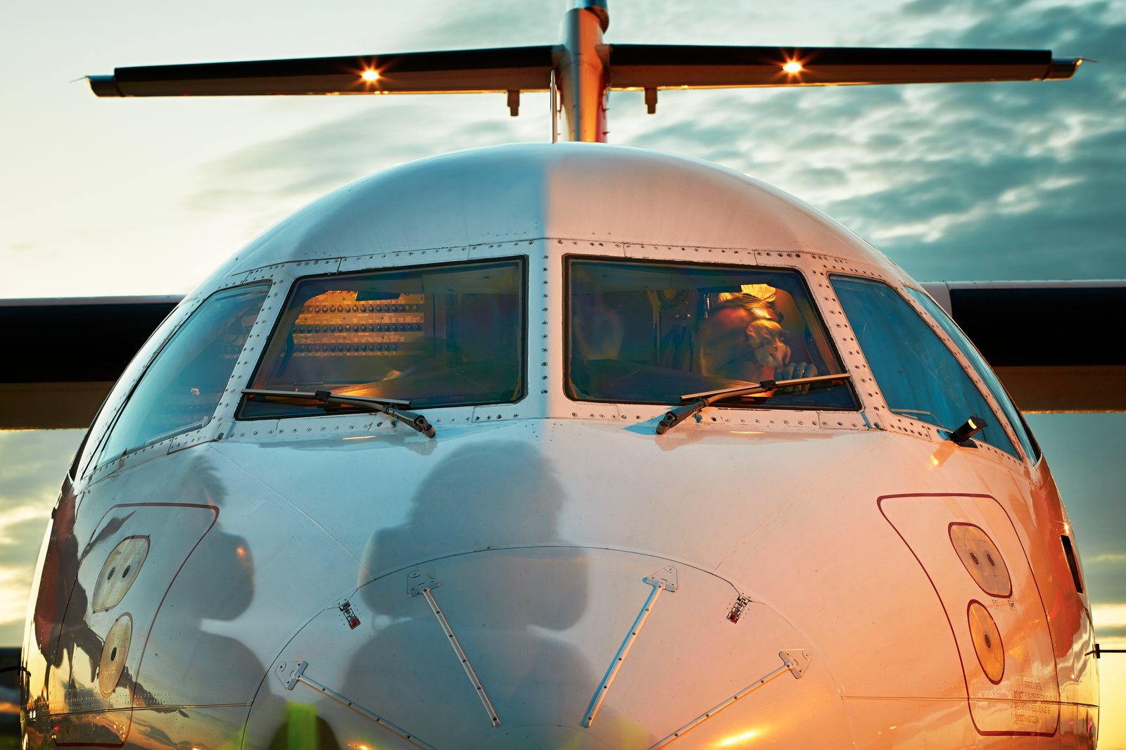 Pilot in the cockpit at sunset
