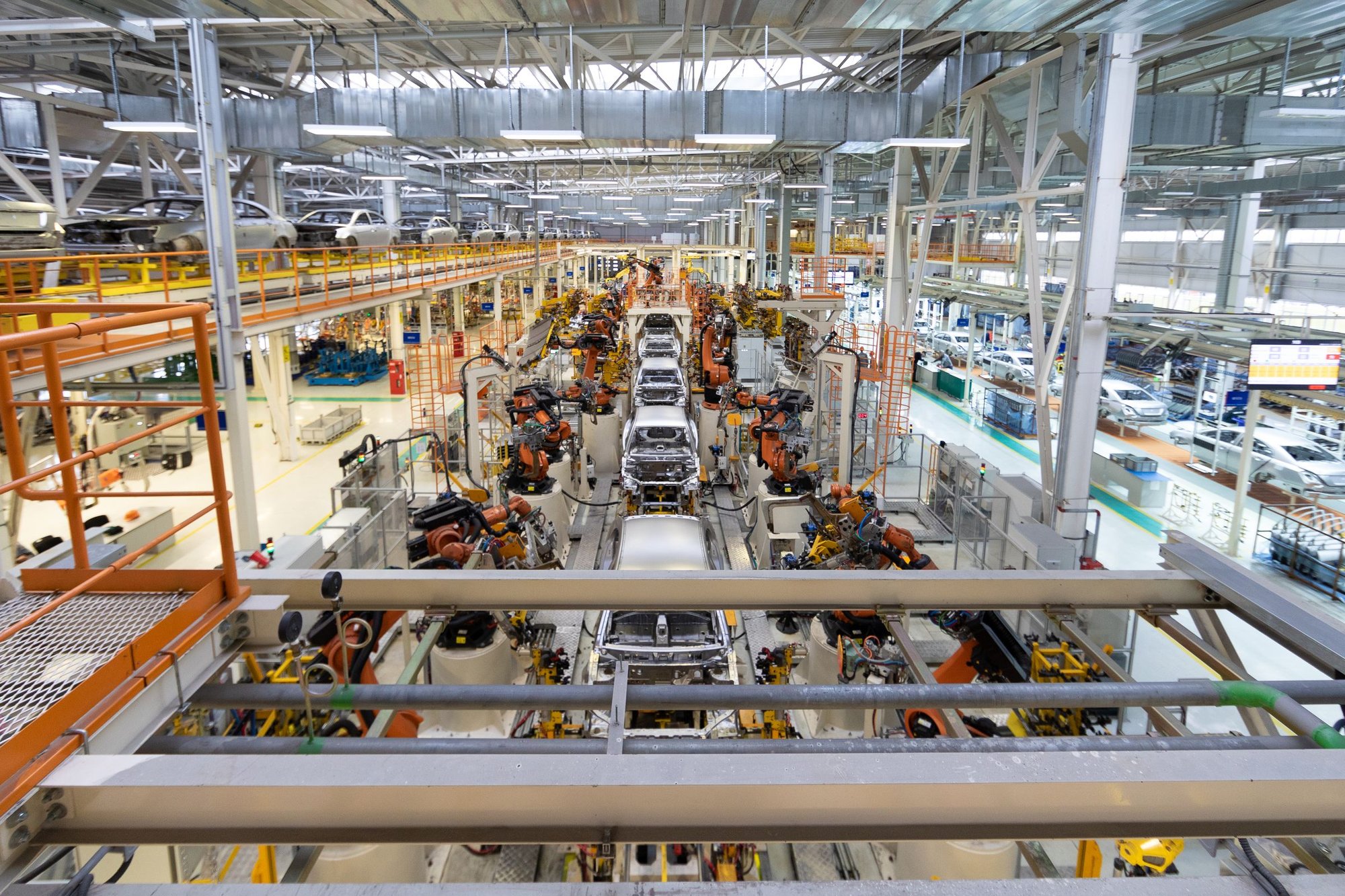 Overhead view of a car body line with orange welding robots