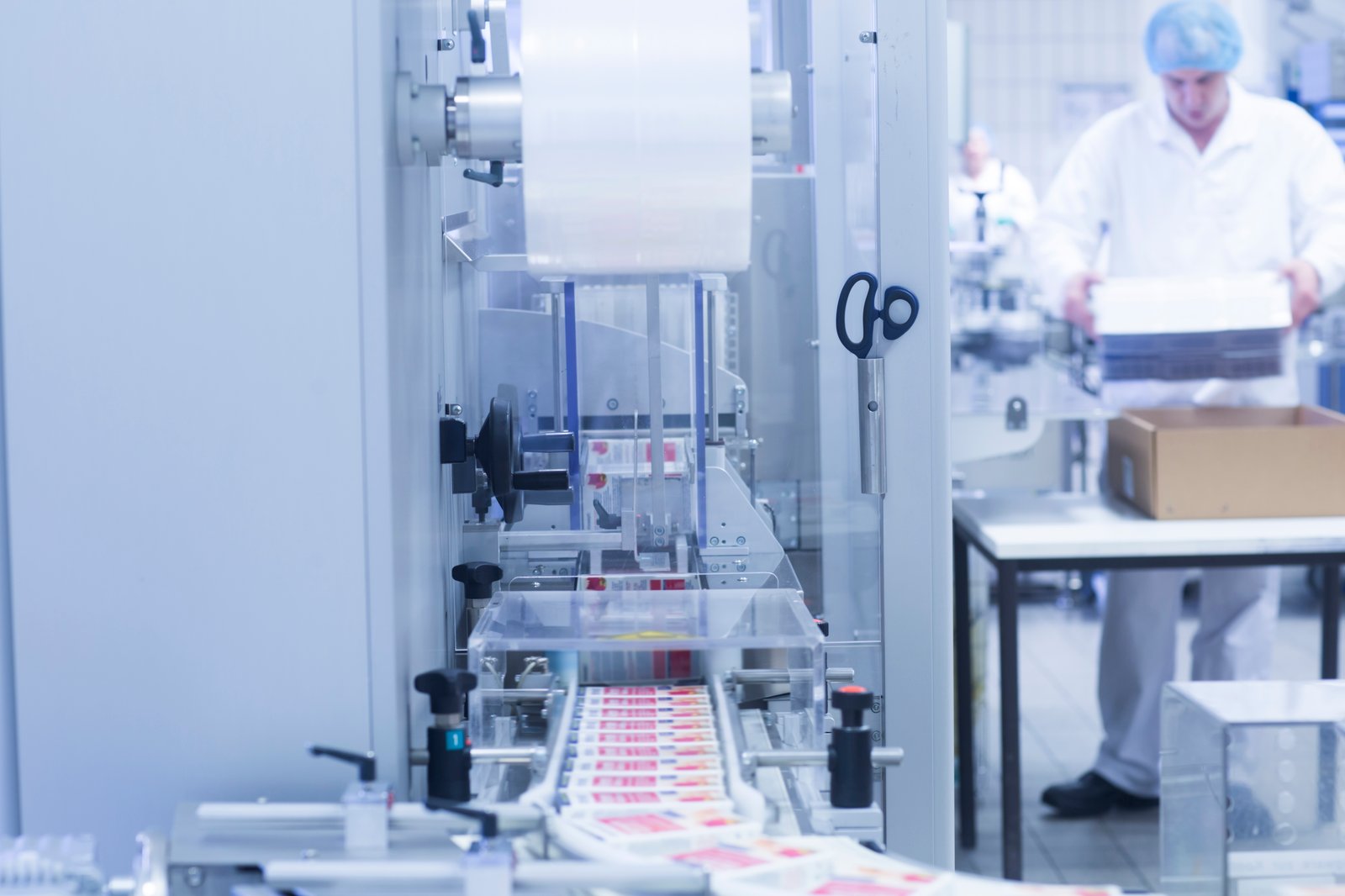 Cartoning machine with a technician loading blanks in a clean room