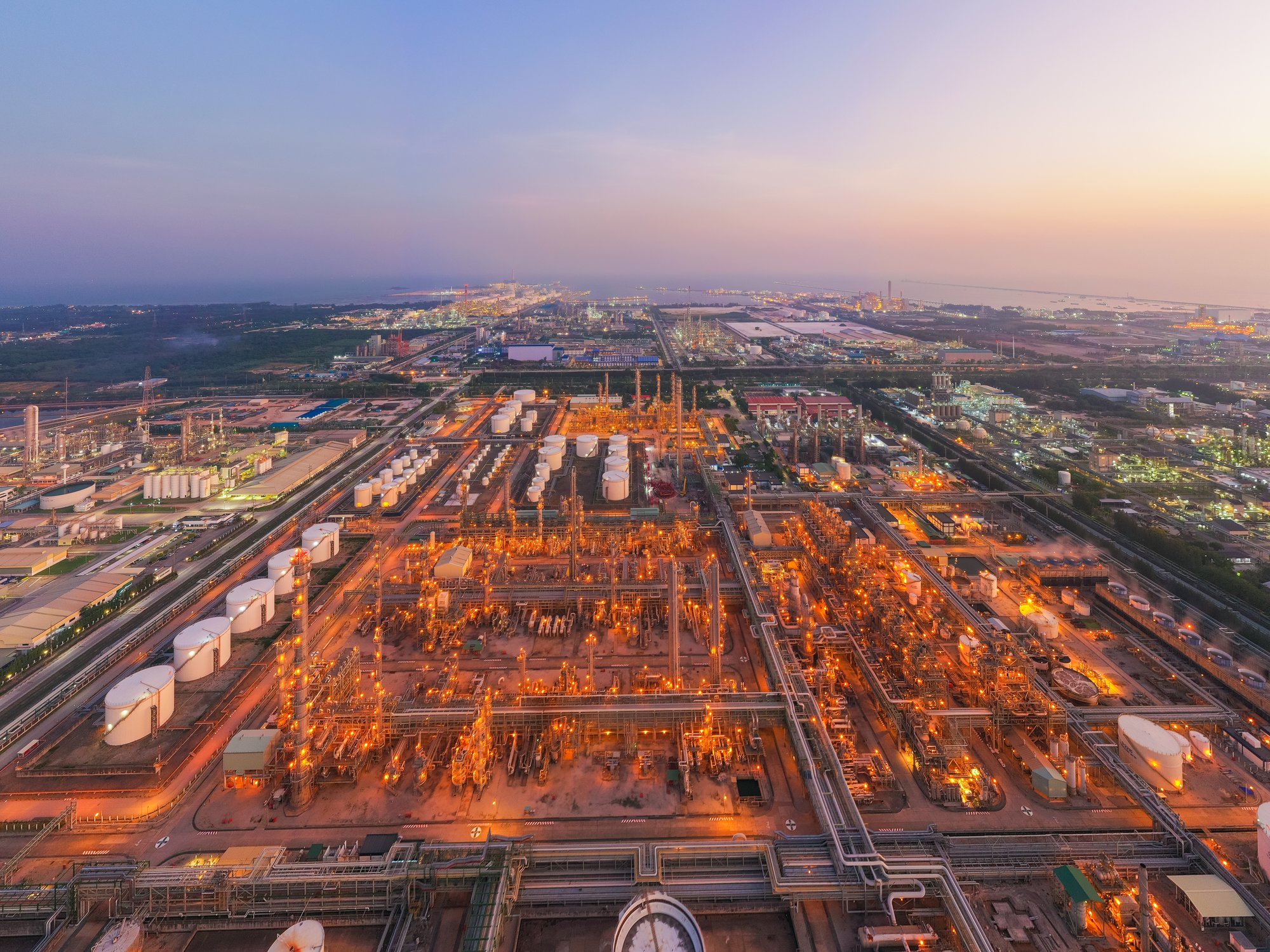 Aerial view of a refinery complex lit at twilight