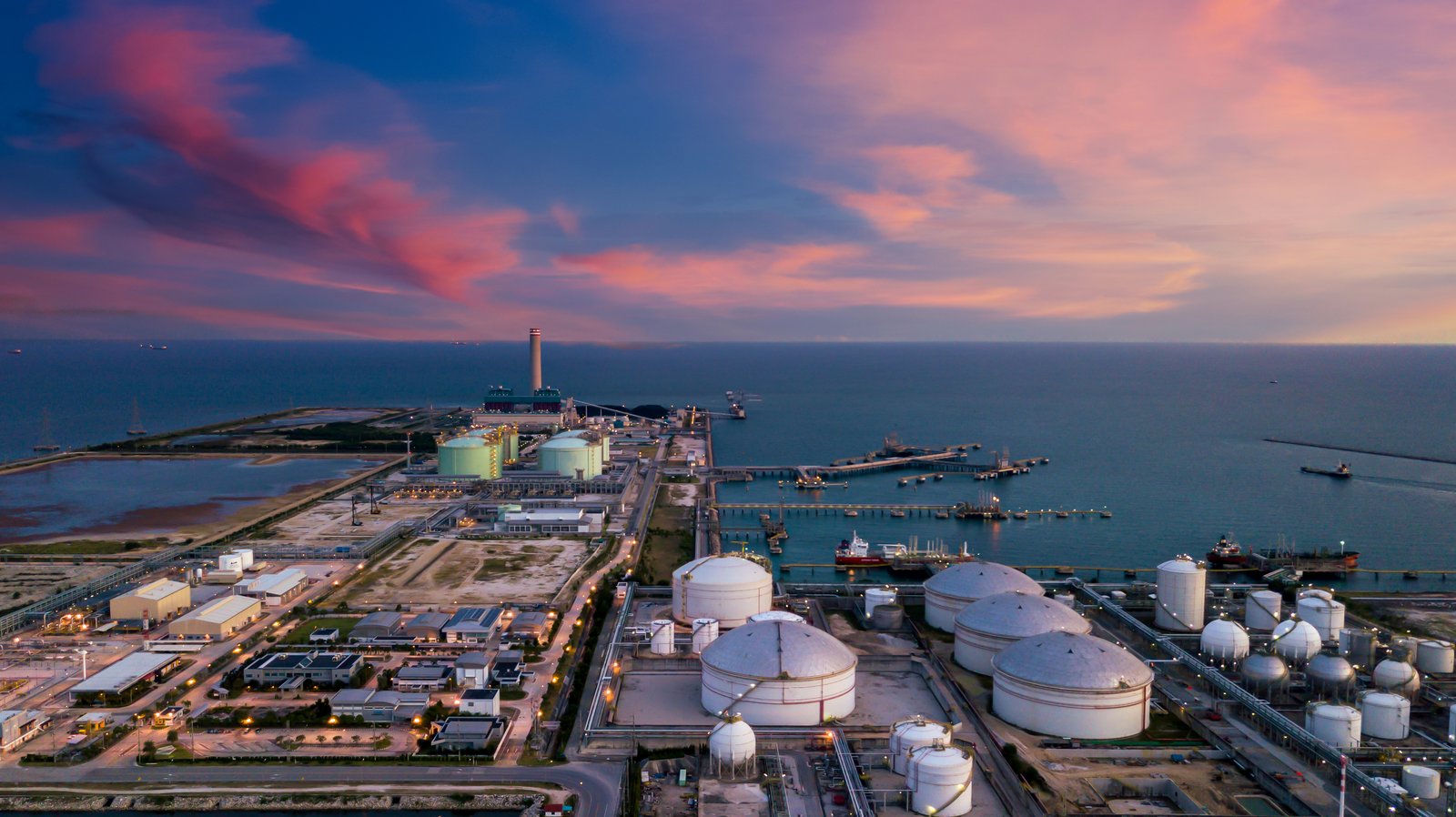 Coastal tank farm and processing site at sunset
