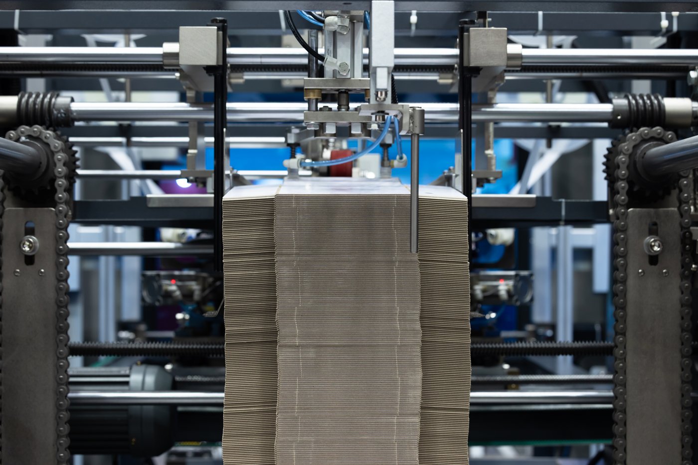 Machine processing a large stack of corrugated cardboard