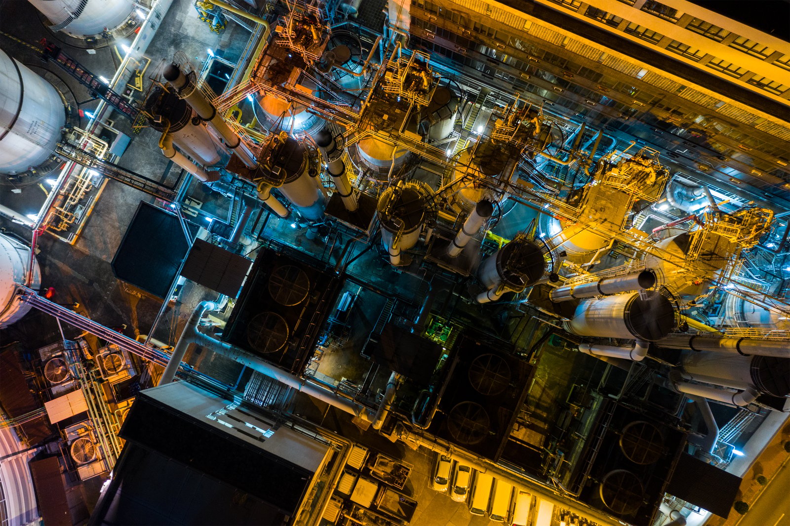 Overhead view of illuminated piping and equipment at a plant at night