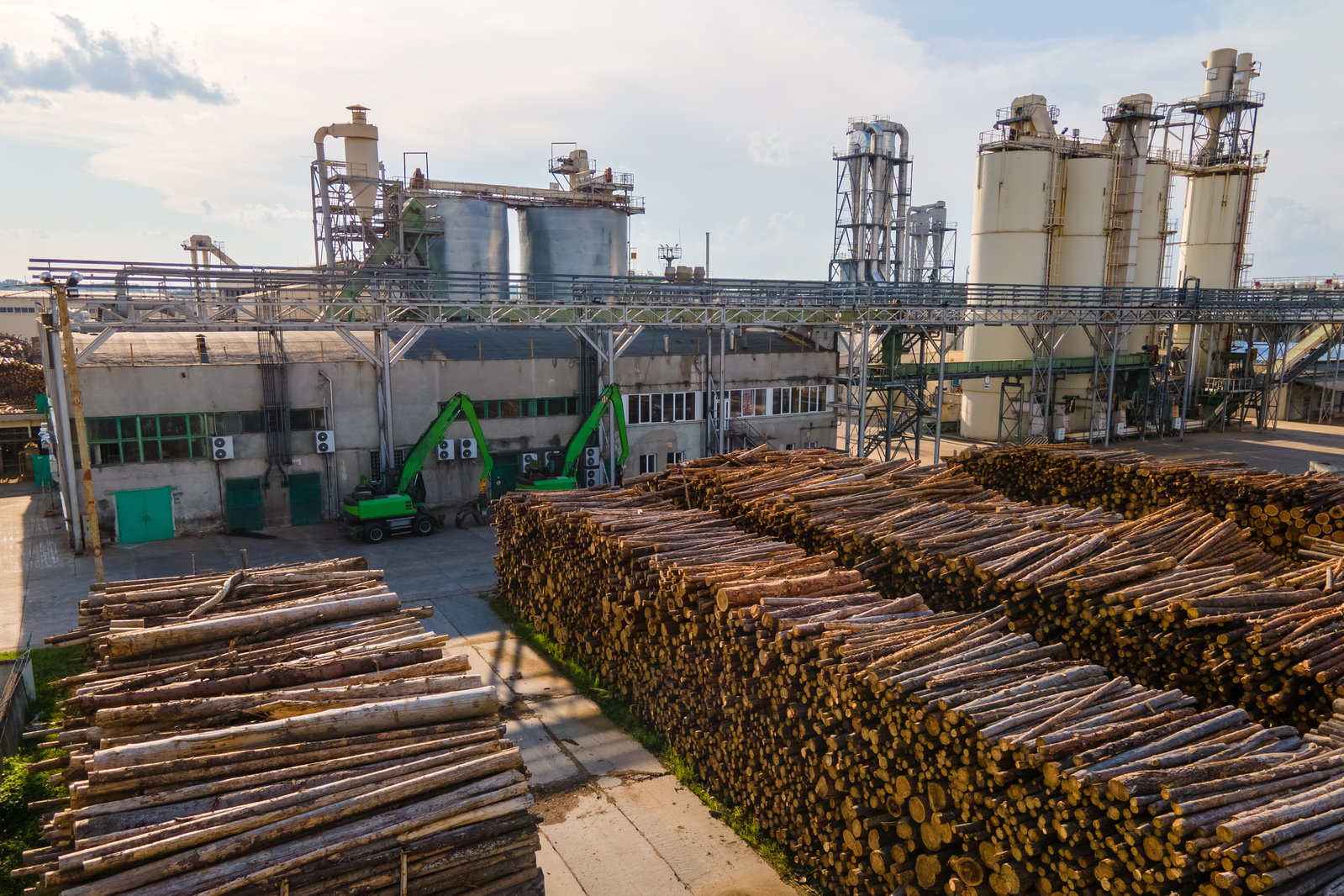 Log yard with stacked timber in front of a pulp mill