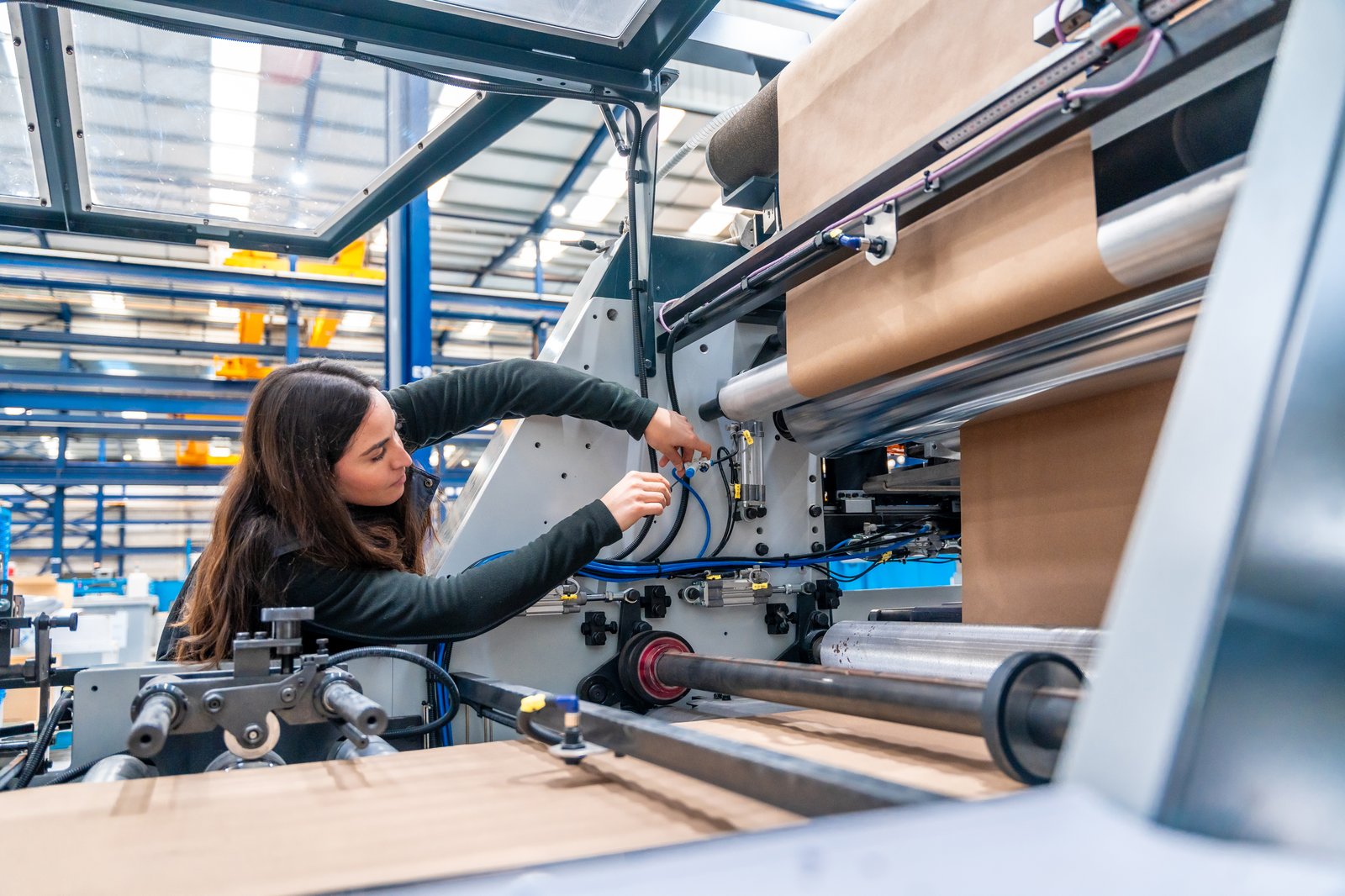Operator adjusting a roll on a converting machine